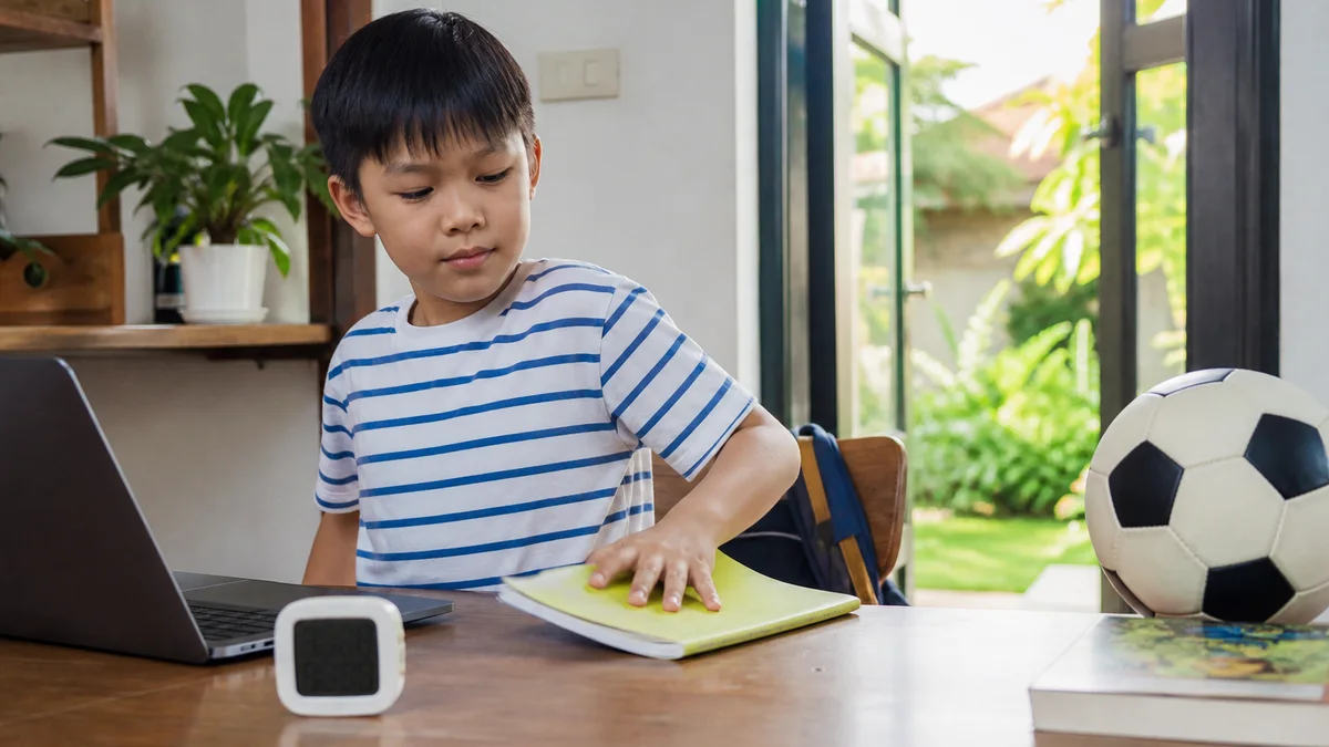 Bé kết thúc buổi học ngắn bên máy tính để chuyển sang đọc sách và chơi bóng